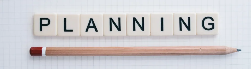 Fichas de letras que forman la palabra PLANNING junto a un lápiz