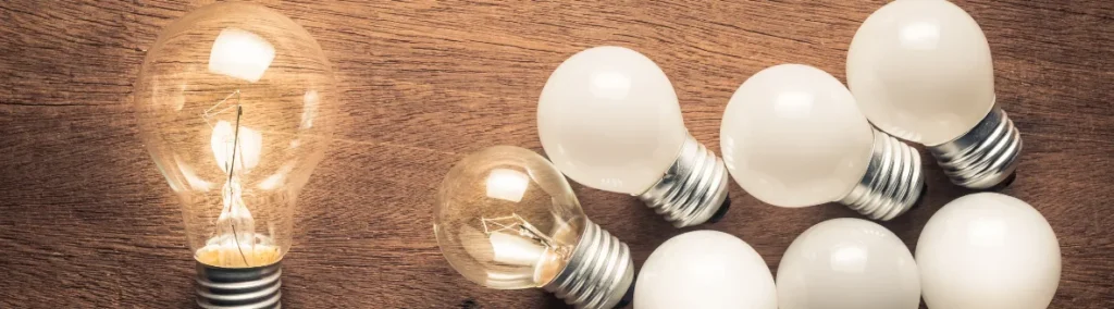 Bombillos sobre una mesa de madera con uno encendido