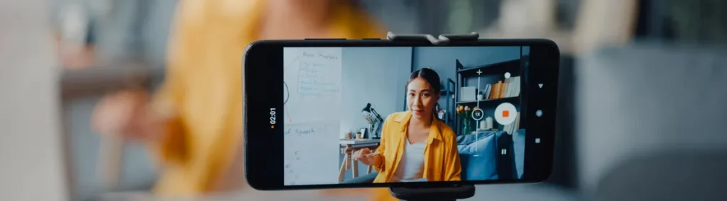 Celular en trípode grabando a una mujer que habla a la cámara