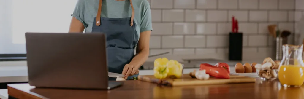 Mujer en la cocina con su portátil abierto